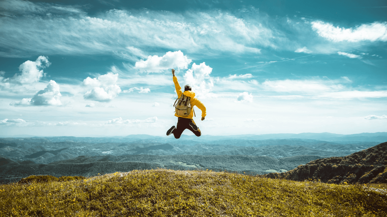 A man celebrating after climbing a tall mountain in Chelan, Wa